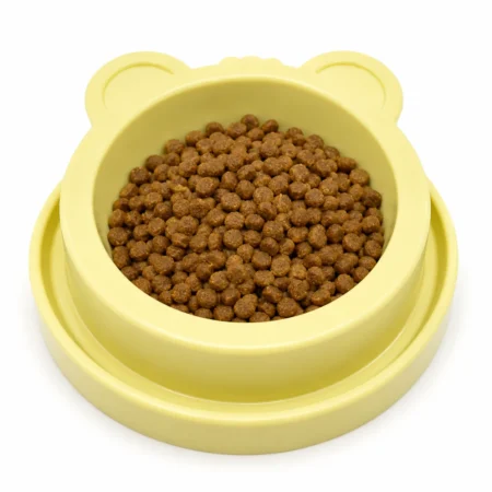 Yellow bear-shaped anti-ant cat bowl filled with dry cat food