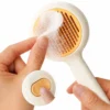 Round self-cleaning slicker brush removing collected pet hair with one-click button.